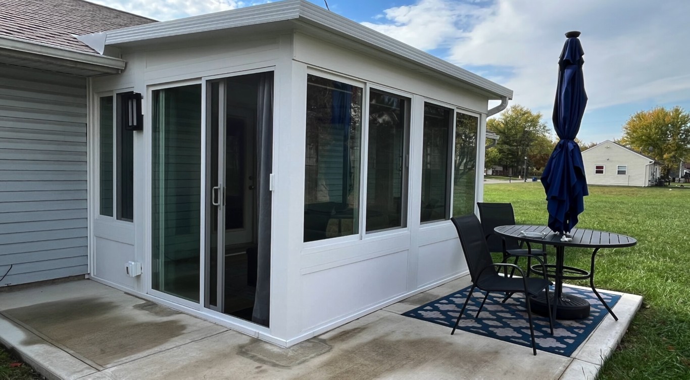 Three-season sunroom with sliding glass doors on concrete patio